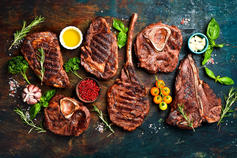 A chalkboard-style diagram titled 'BEEF CUTS' showing a side profile of a cow with labeled meat sections such as head, neck, rib, loin, flank, round, and shank on a dark green chalkboard background.